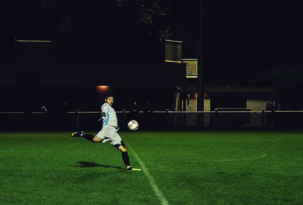 a soccer player and a soccer ball on a football field
